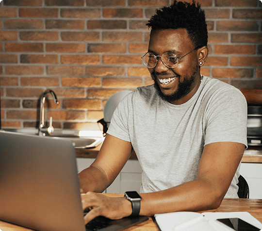 Smiling african business man using laptop